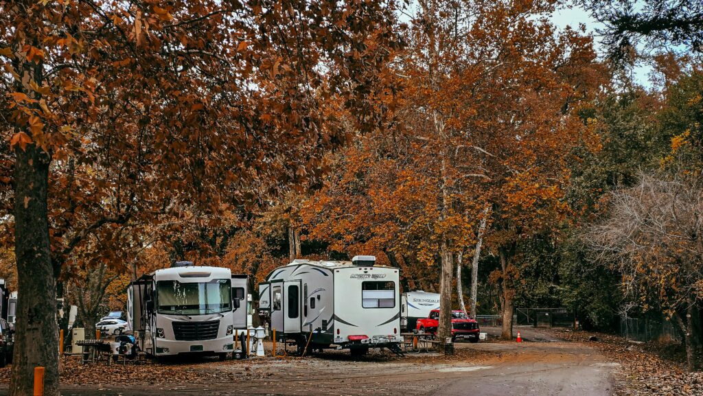 Cozy RV campsite surrounded by vibrant fall foliage in a serene forest.